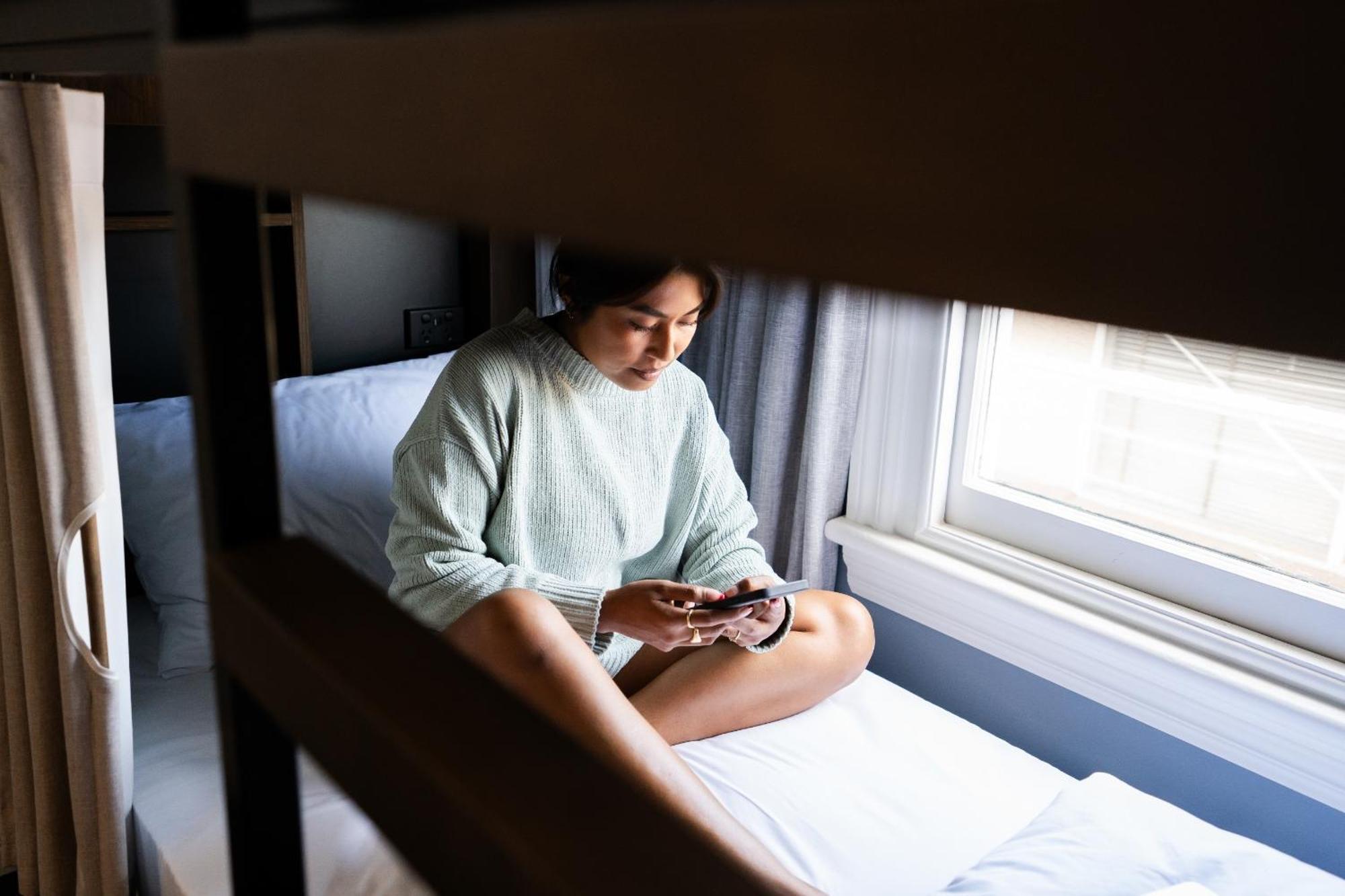 Yha ロトルアホステル エクステリア 写真 A woman sitting on a bunk bed